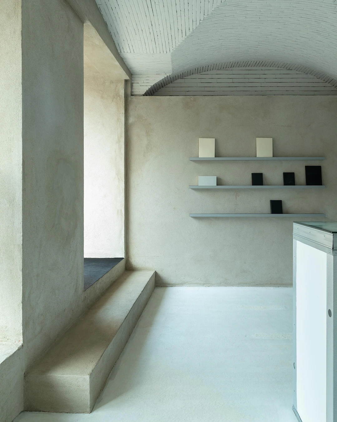 Inside the Fairly Normal flagship on Rua de São Paulo: plaster walls, a vaulted brick ceiling and slim wall shelves